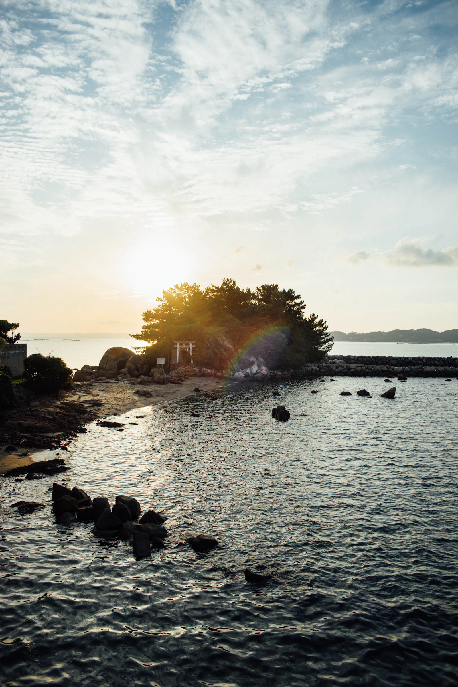 夕日に照らされた岩場と静かな海